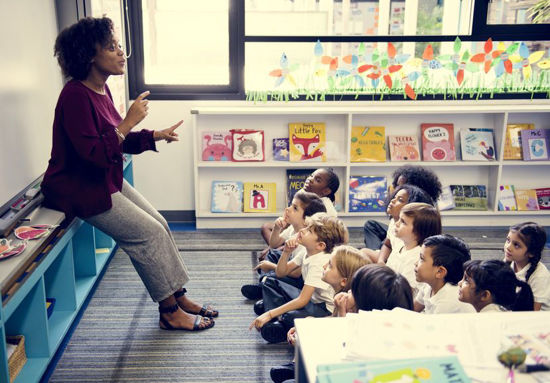 woman in front of a class of children