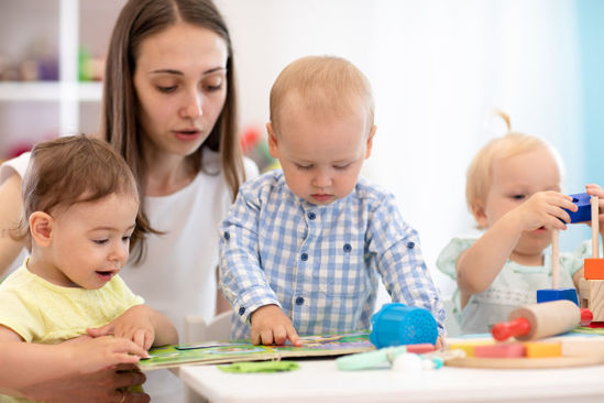 woman looking at book with children