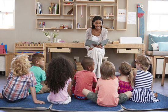 woman reading book to children